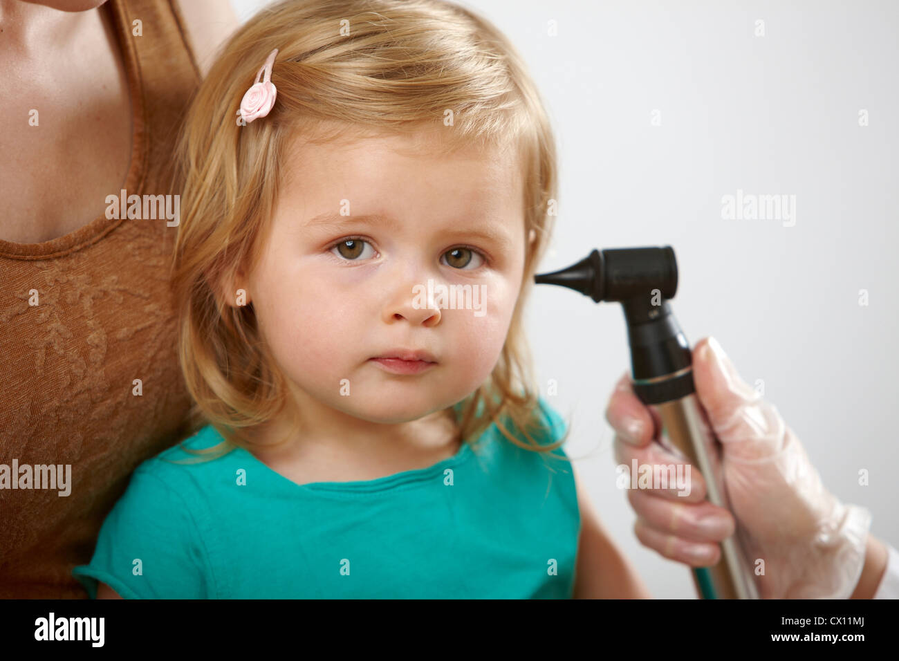 Bambina avente il suo orecchio controllato Foto Stock