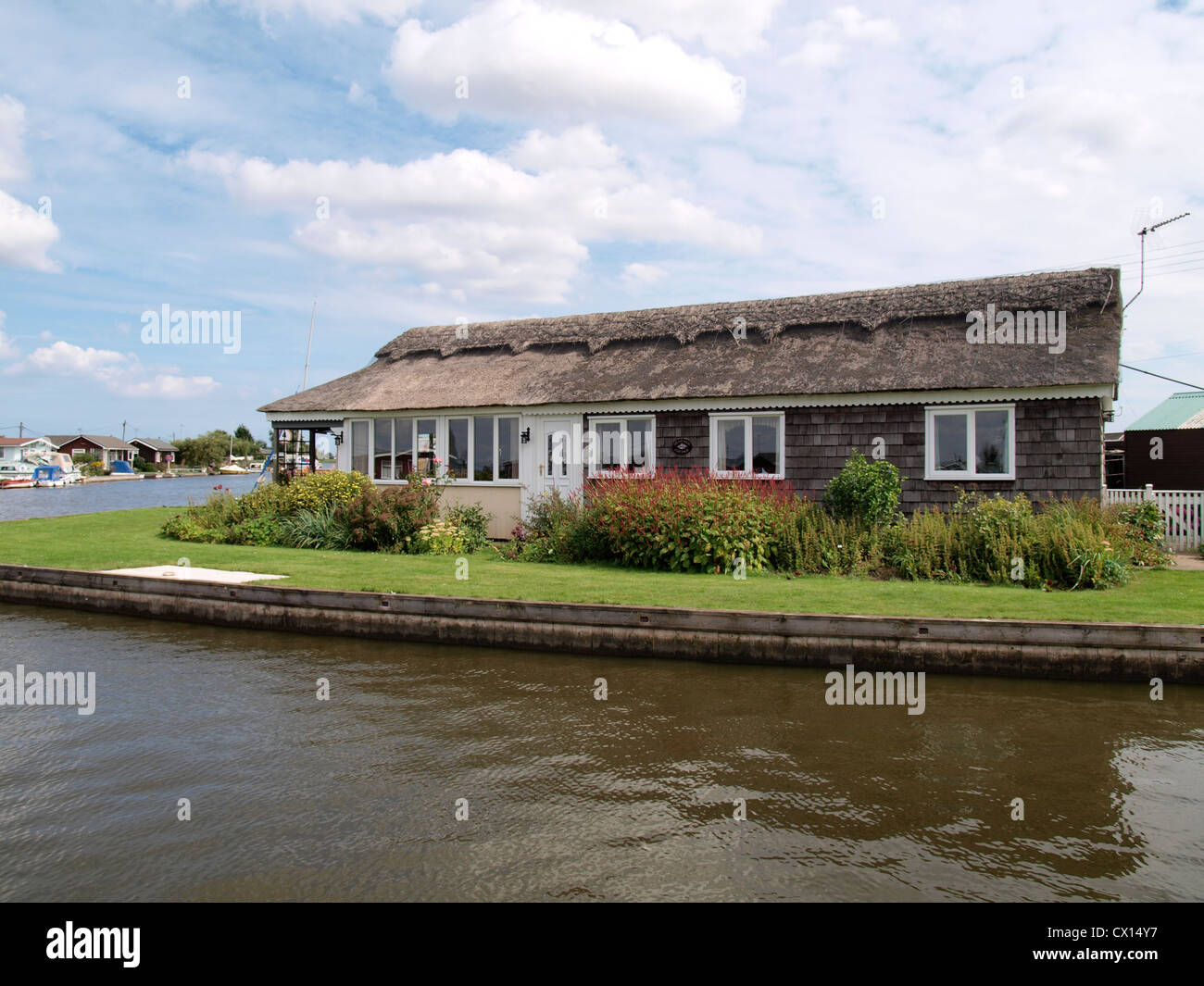 Bungalow con tetto in paglia, Fiume Thurne a Potter Heigham, Norfolk, Regno Unito Foto Stock