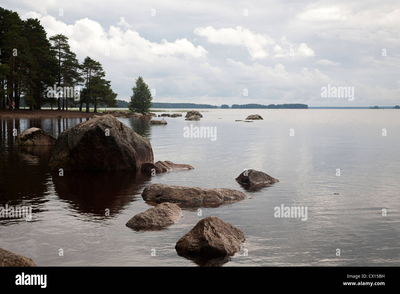 Banca con massi del lago svedese Hedesunda Fjärden, Gasterikland, Svezia Foto Stock