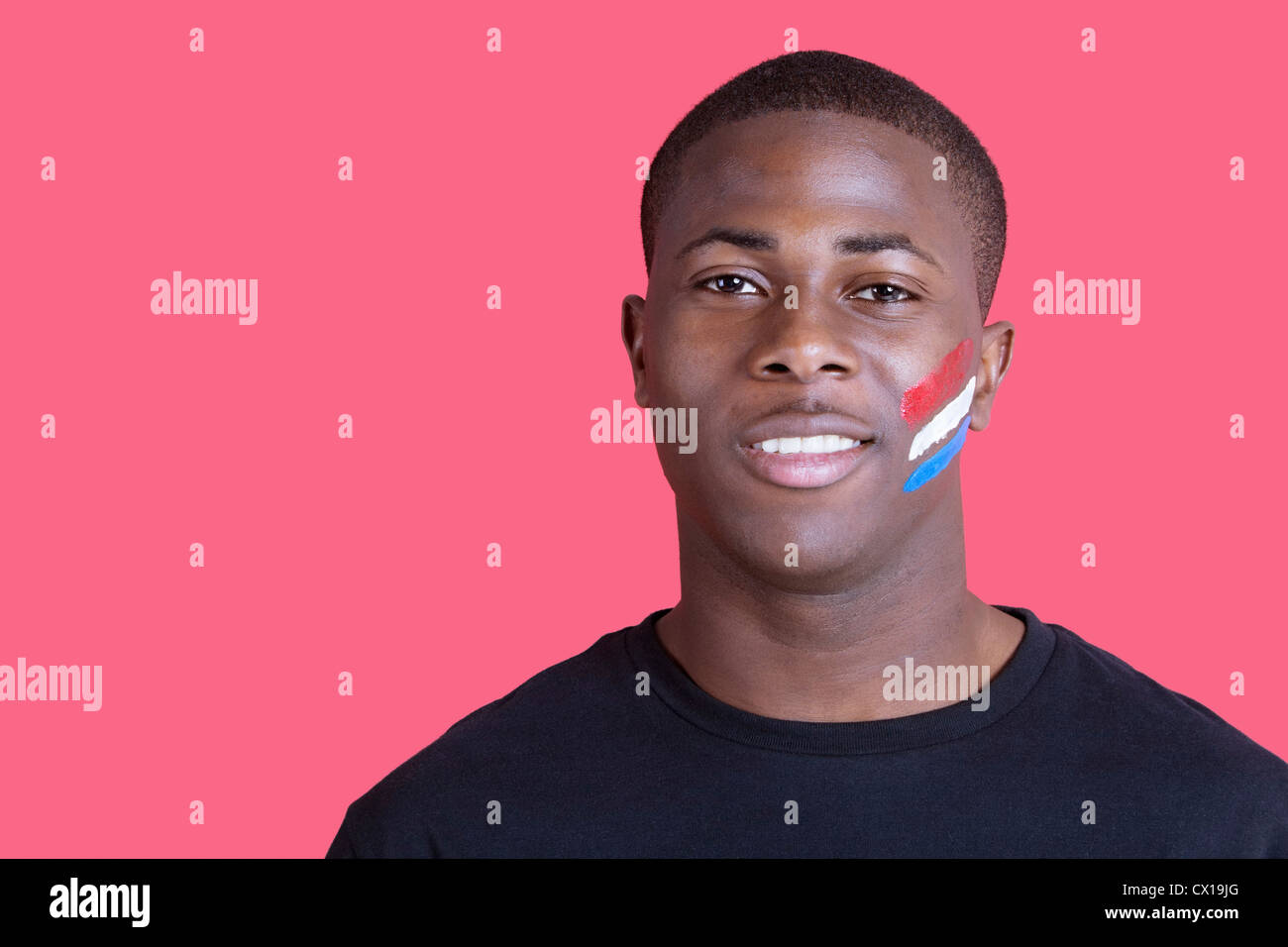 Ritratto di afro-americano con bandiera olandese sul suo volto su sfondo rosa Foto Stock