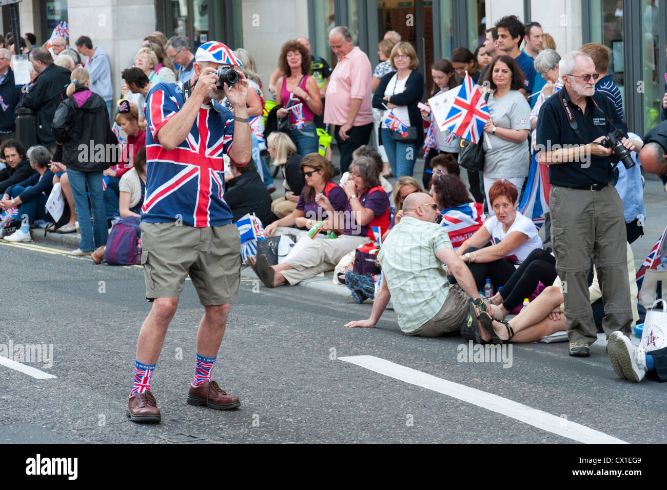 Uno spettatore in Unione Jack vestiti prende le foto alla Olimpiadi di Londra 2012 Team GB Victory Parade London REGNO UNITO Foto Stock