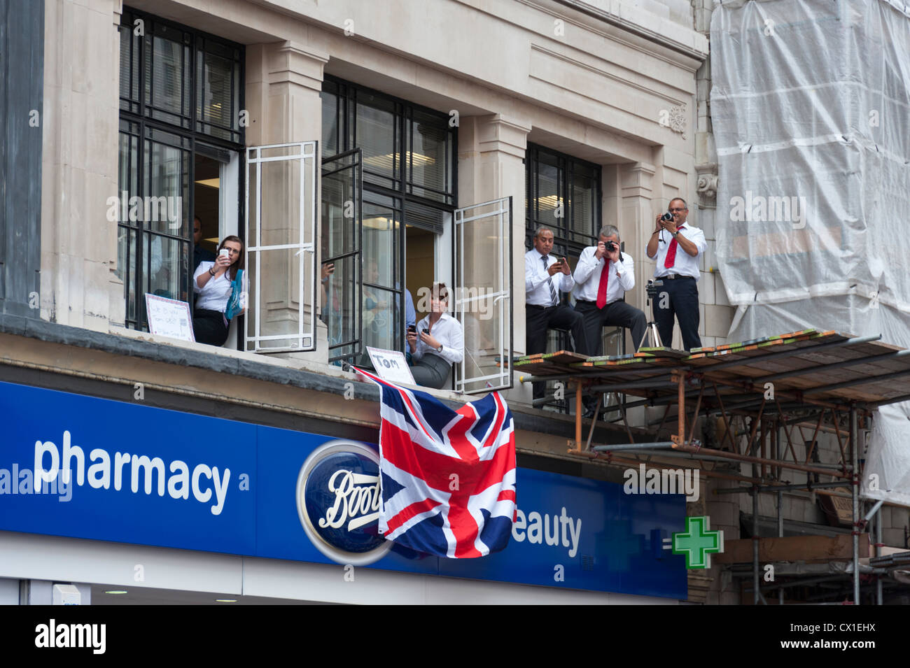 Spettatori guardare da un ufficio presso le Olimpiadi di Londra 2012 Team GB Victory Parade London REGNO UNITO Foto Stock