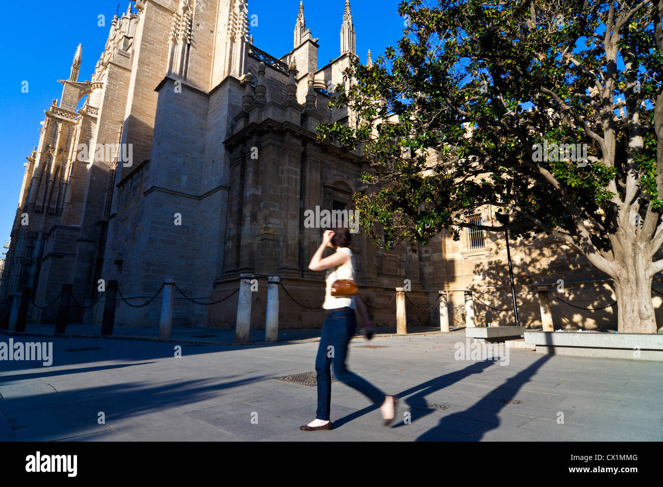 Giovane donna a piedi dalla Cattedrale di Siviglia, Siviglia, Andalusia, Spagna Foto Stock