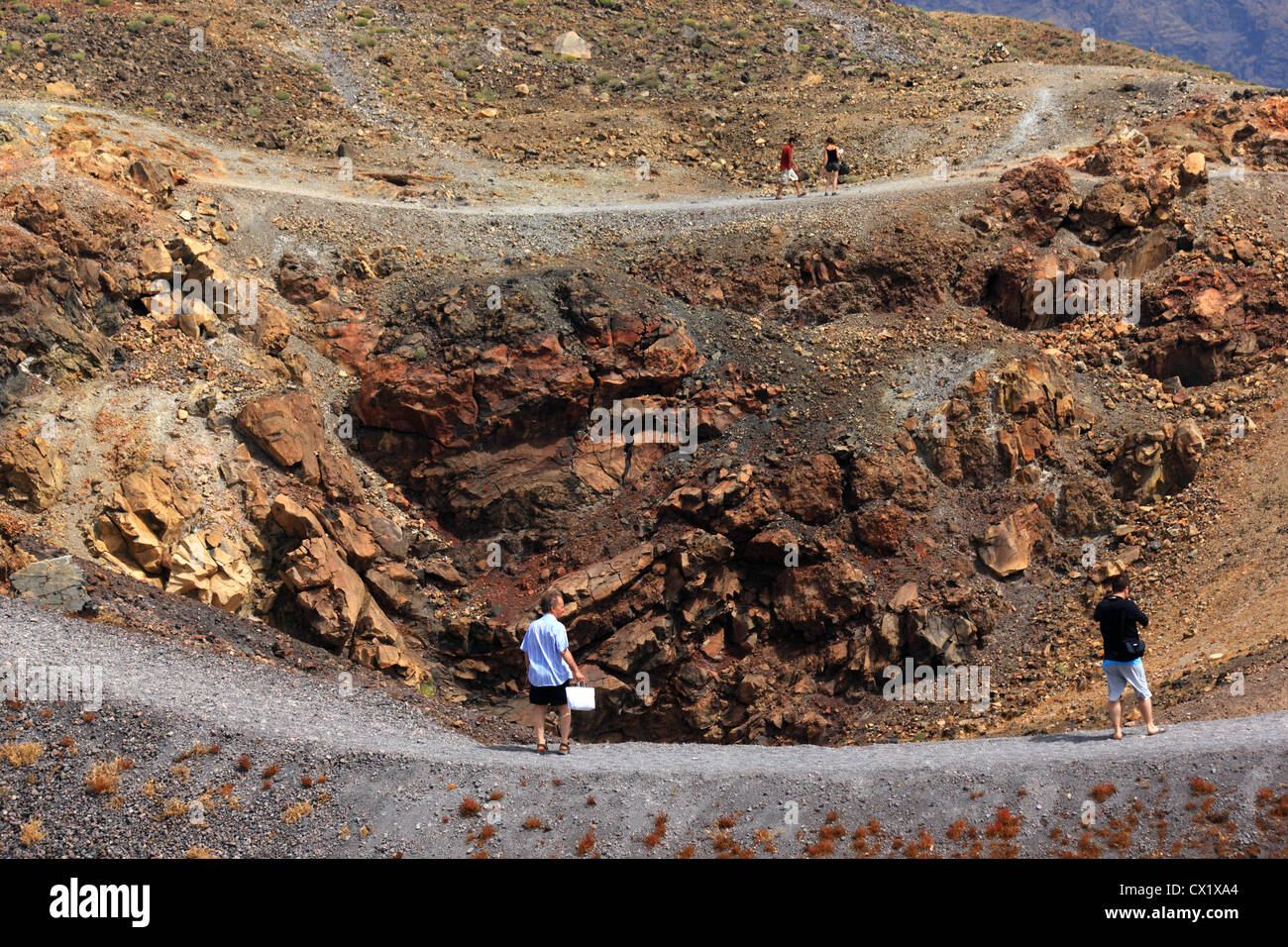 I turisti camminando sul bordo del cratere attivo su Nea ("Nuovo") Kammeni isola nel cuore della caldera di Santorini. Foto Stock