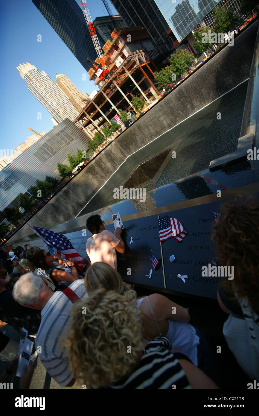 Persone hanno lasciato le bandiere e fiori sul 9/11 Twin towers memorial. Foto Stock