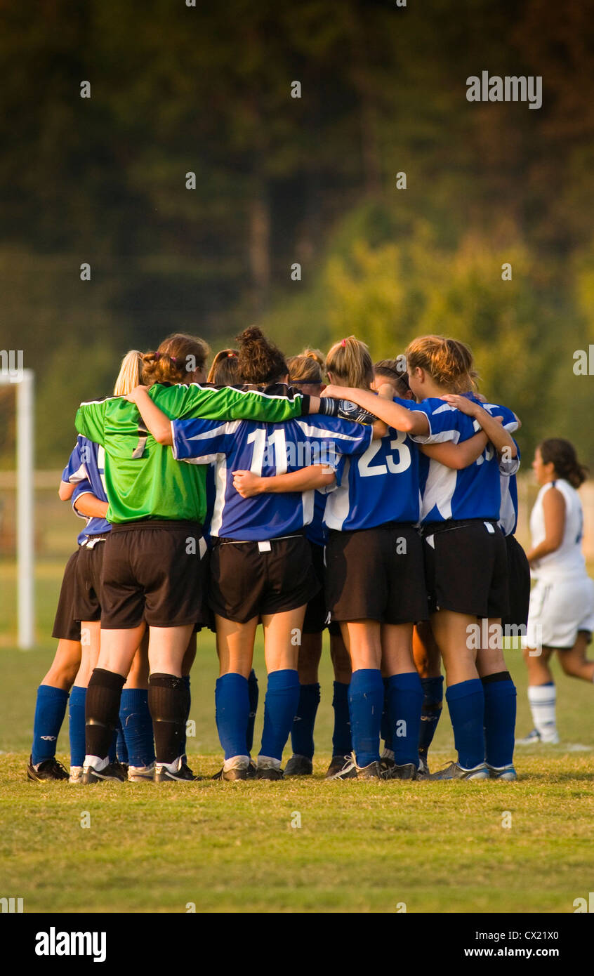 Collegio universitario femminile di squadra di calcio in un huddle tra metà. Foto Stock