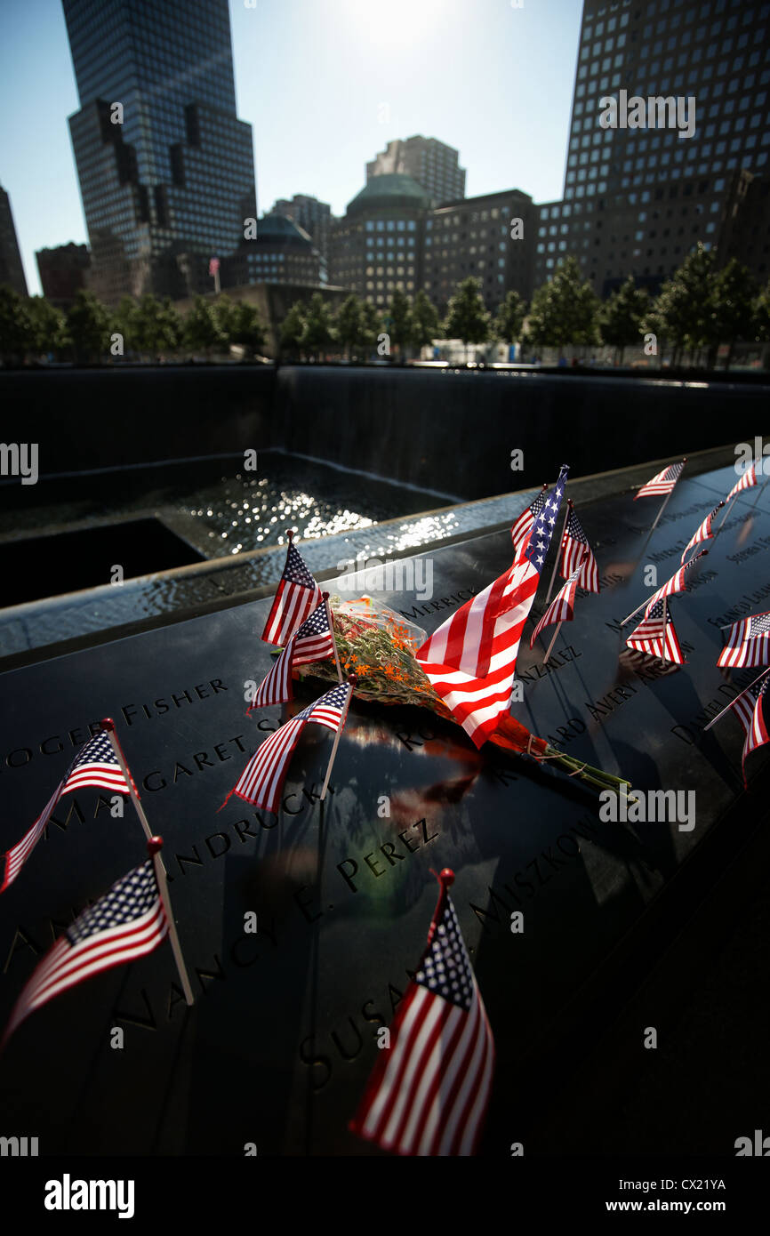 Persone hanno lasciato le bandiere e fiori sul 9/11 Twin towers memorial. Foto Stock