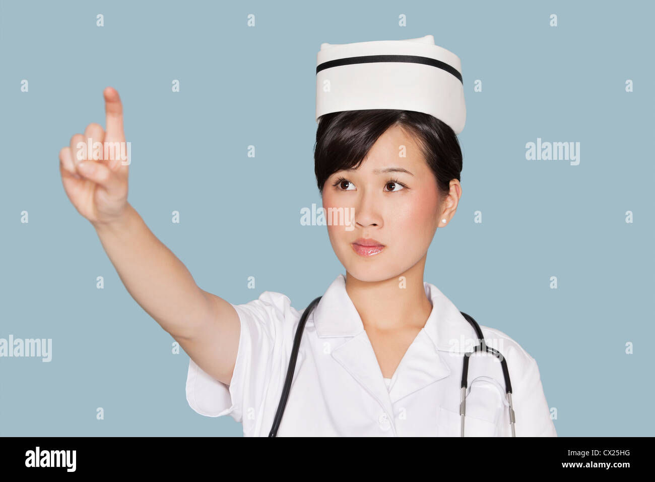 Giovani donne medico utilizzando lo schermo trasparente su fondo azzurro Foto Stock