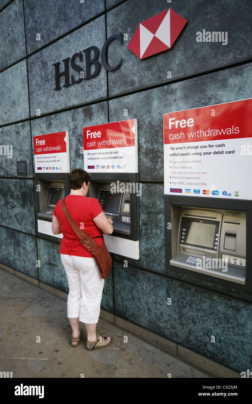 Una donna con un HSBC bancomat a macchina Foto Stock