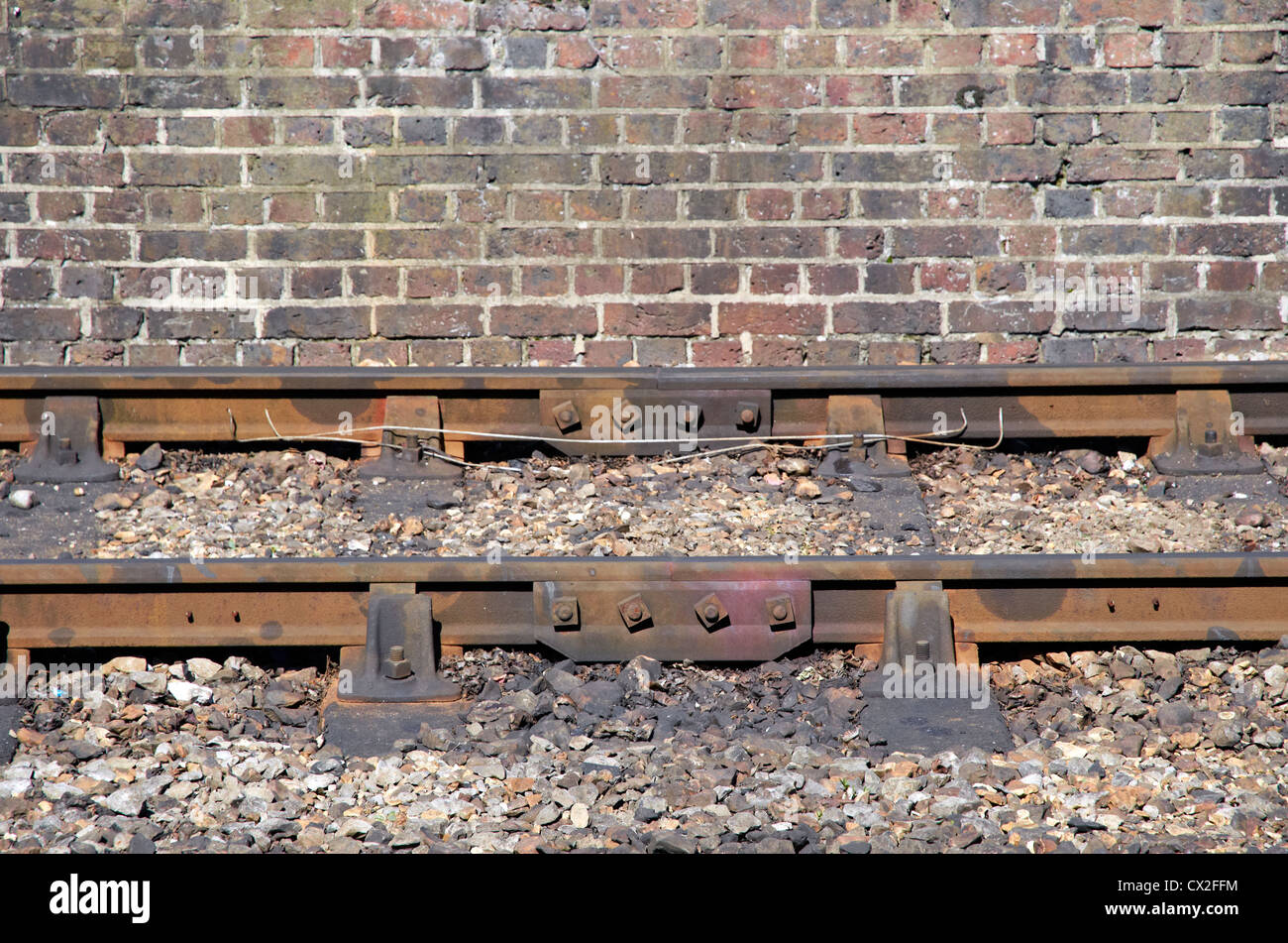 Binario ferroviario - paratia rampa, traversine di cemento. Ferrovia detenute in ghisa sedie di legno/metallo chiave. Piastrone snodi ferroviari Foto Stock