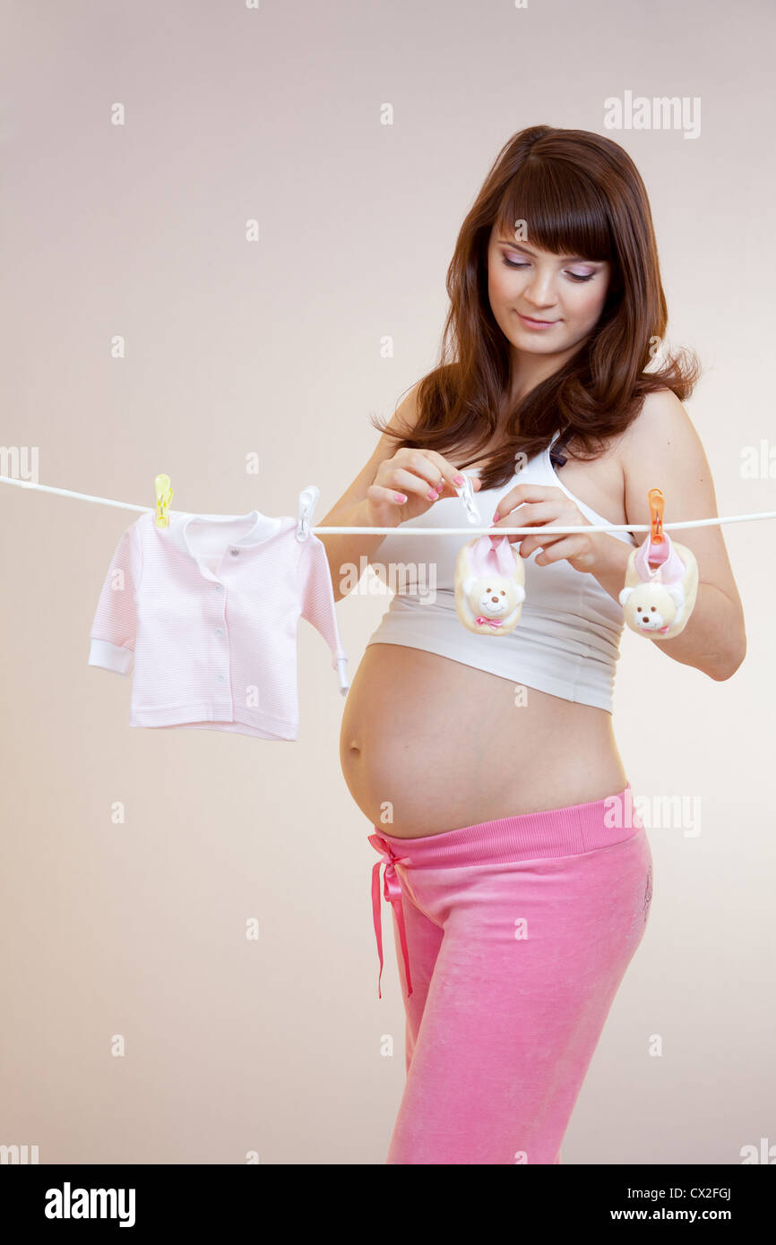 Donna incinta appendere bimbo di accessori sulla fune Foto Stock
