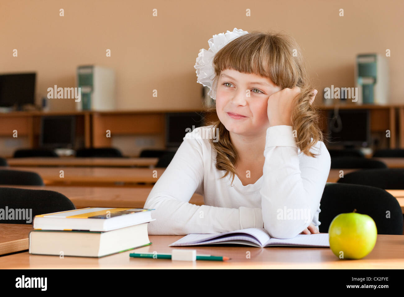 Schoolgirl il ritratto al banco di scuola con i suoi libri Foto Stock