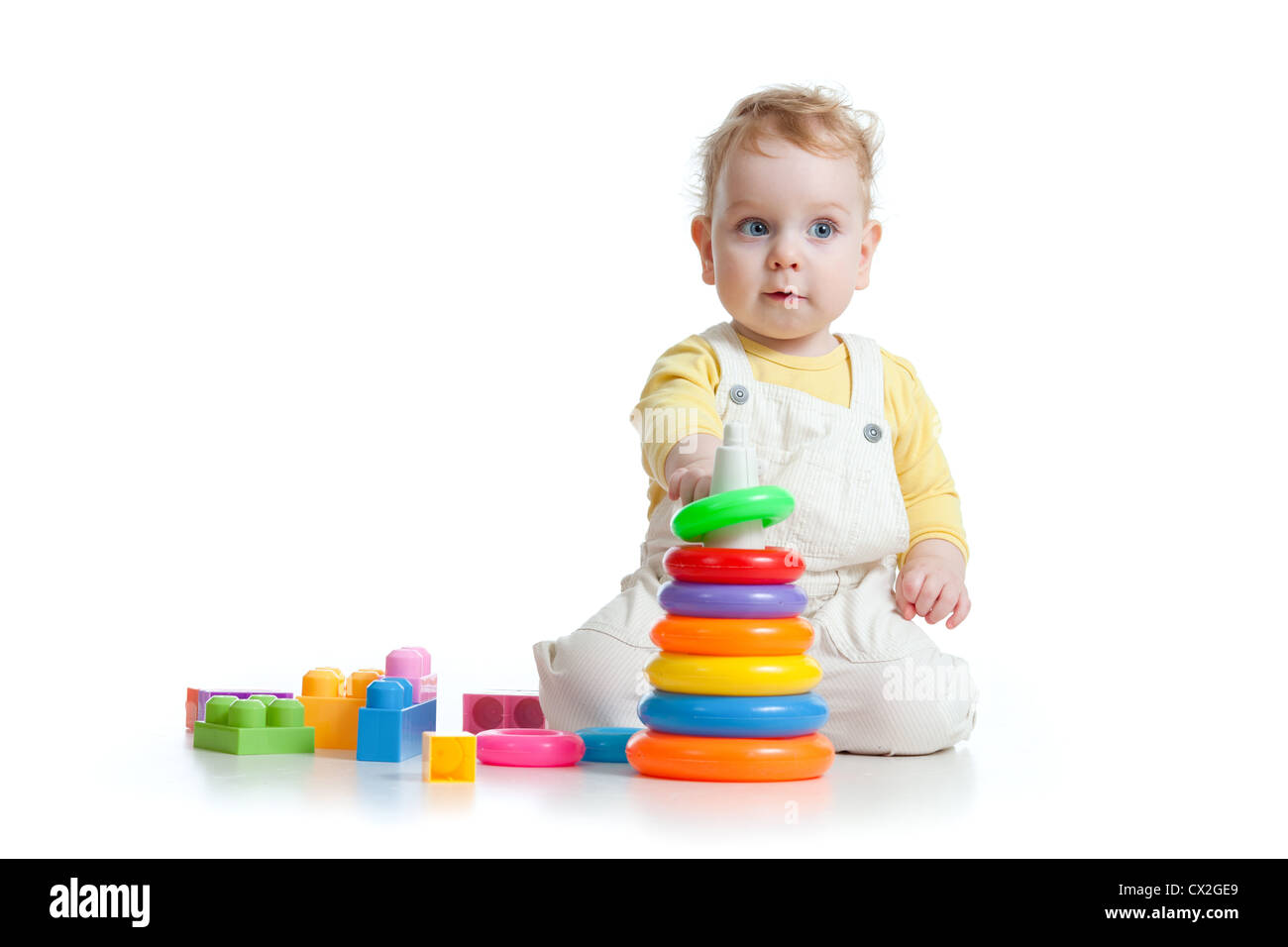 Carino piccolo ragazzo giocando giocattoli colorati isolato su bianco Foto Stock