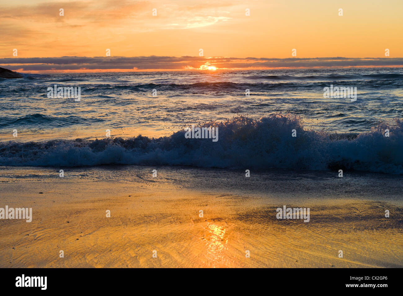 Il tramonto e le onde sulla spiaggia di Llandudno, Western Cape, Sud Africa Foto Stock