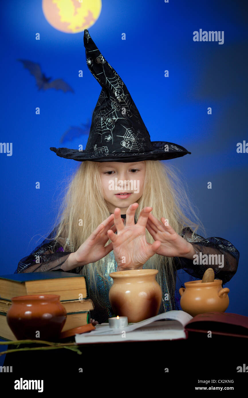 Ragazza vestita come strega in notte rendendo magic Foto Stock