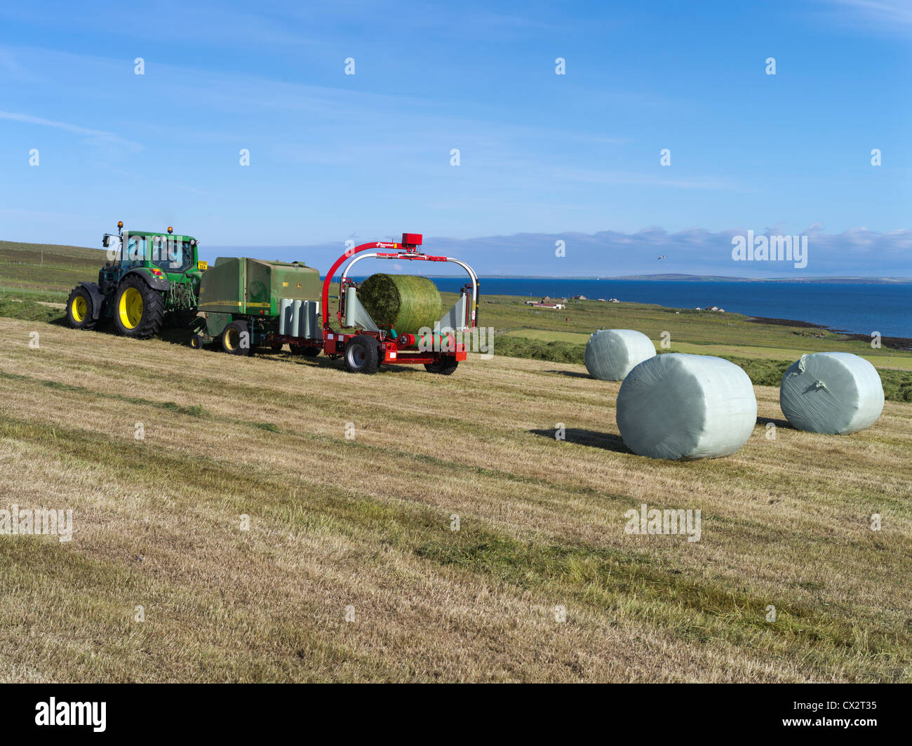 Trattore dh John Deere PER LA RACCOLTA di balle per il Regno Unito per la raccolta di balle per la produzione di balle per balle per fieno in Scozia Foto Stock