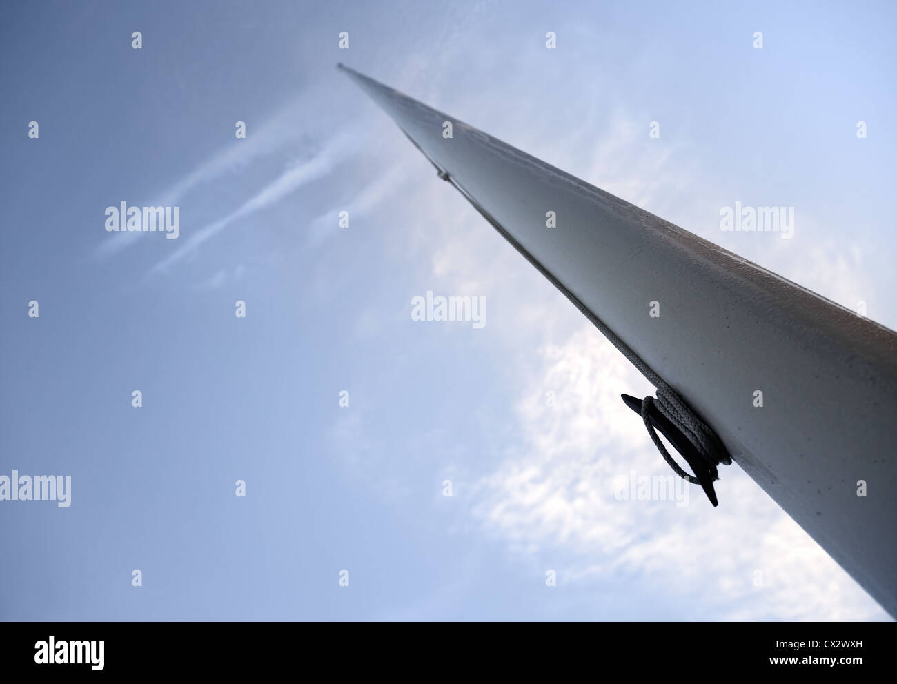 Svuotare pennone vista prospettica contro profondo cielo blu con nuvole che somiglia a una bandiera Foto Stock