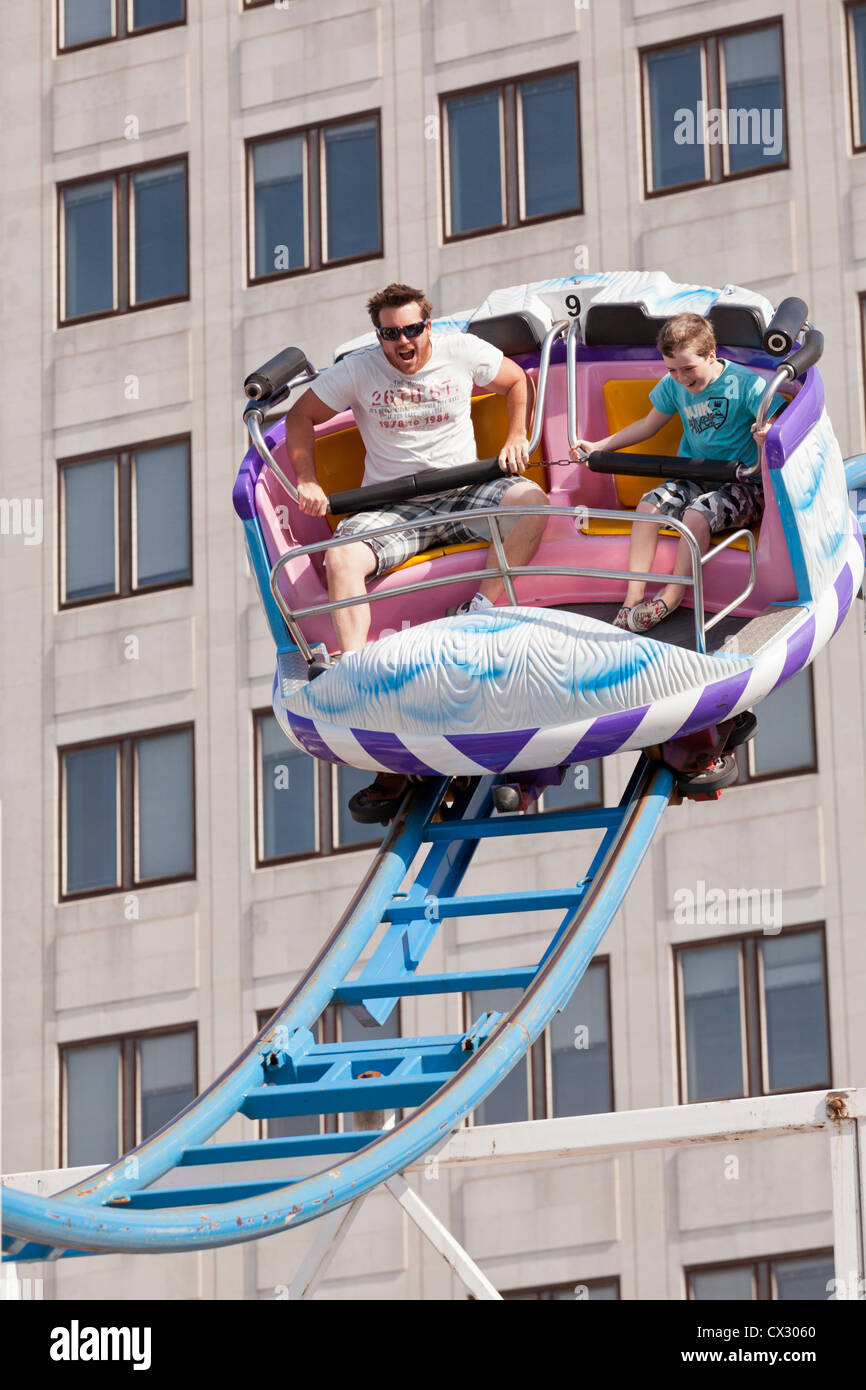 Un uomo e un ragazzo nella cabina di un roller coaster in procinto di fare una ripida discesa a sindaco di Thames Festival a Londra Foto Stock