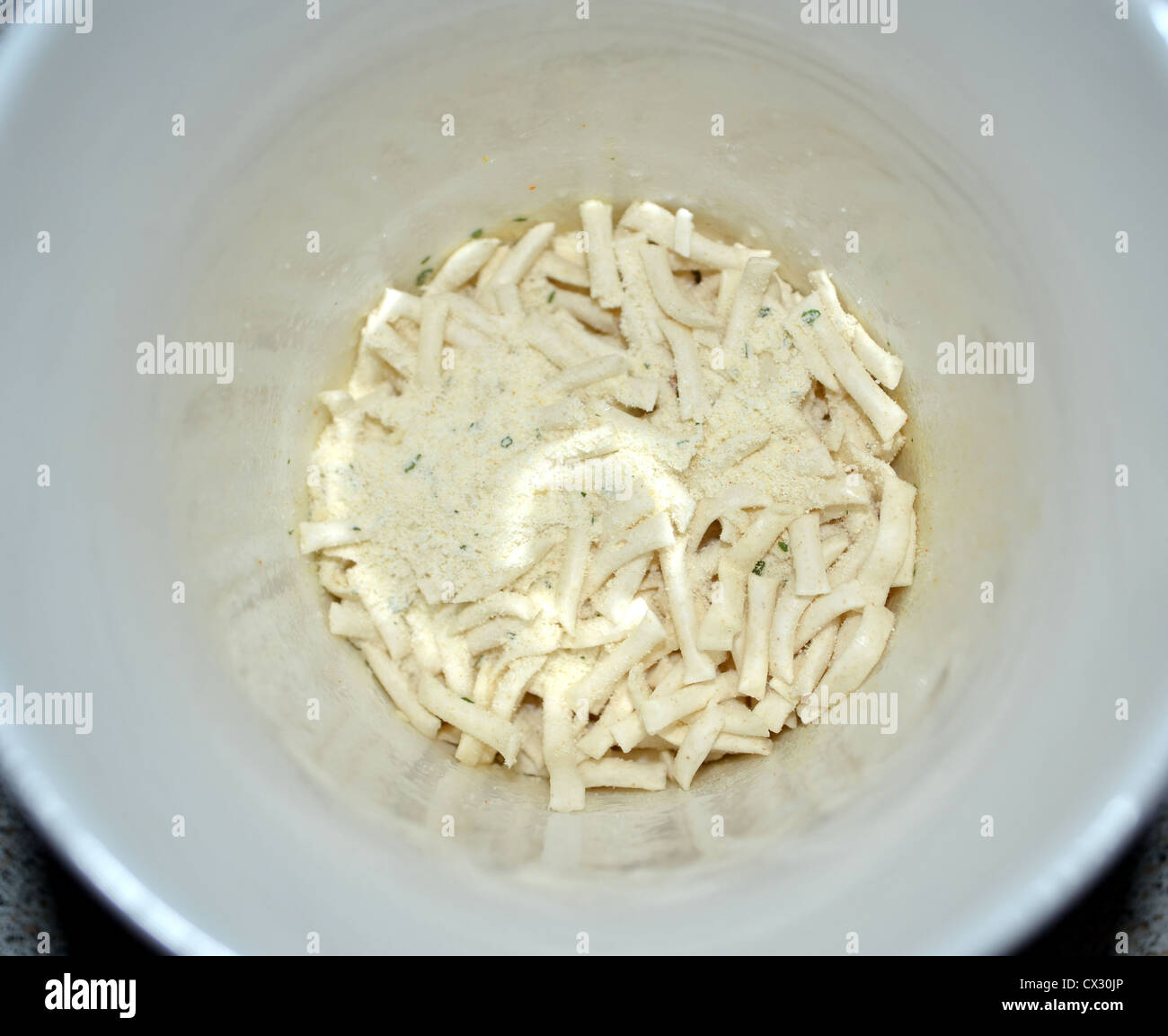 Birdseye vista Dried Noodles e aromatizzante nel fondo di una tazza in attesa di versare acqua bollente Foto Stock