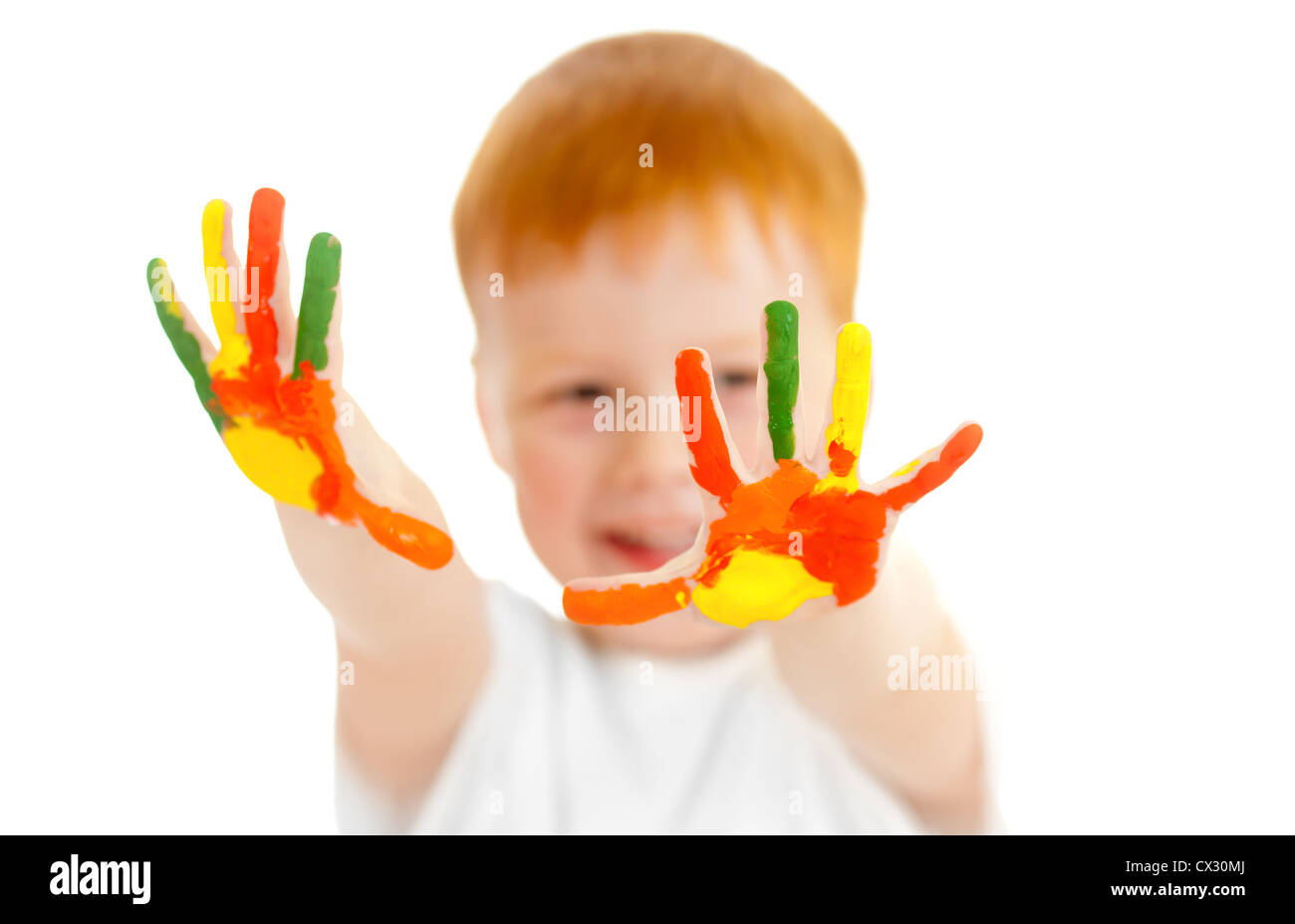 Adorabili redheaded ragazzo con focus su mani dipinte in colori vivaci Foto Stock