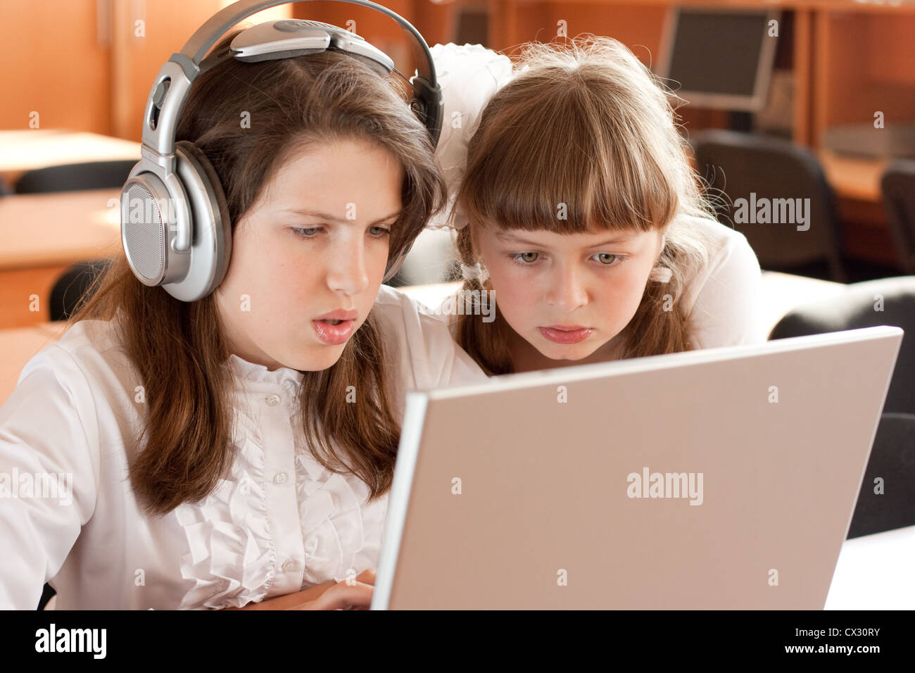 Due studentesse concentrati sul loro compito con i notebook Foto Stock