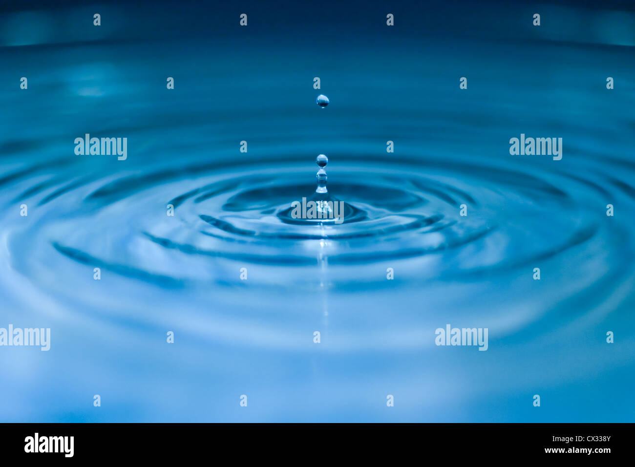 Schizzi di acqua goccia closeup in tonalità blu Foto Stock