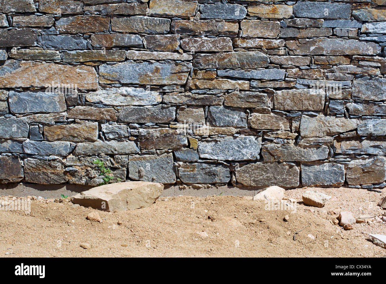 Una pietra di granito a parete e pavimento in sabbia Foto Stock