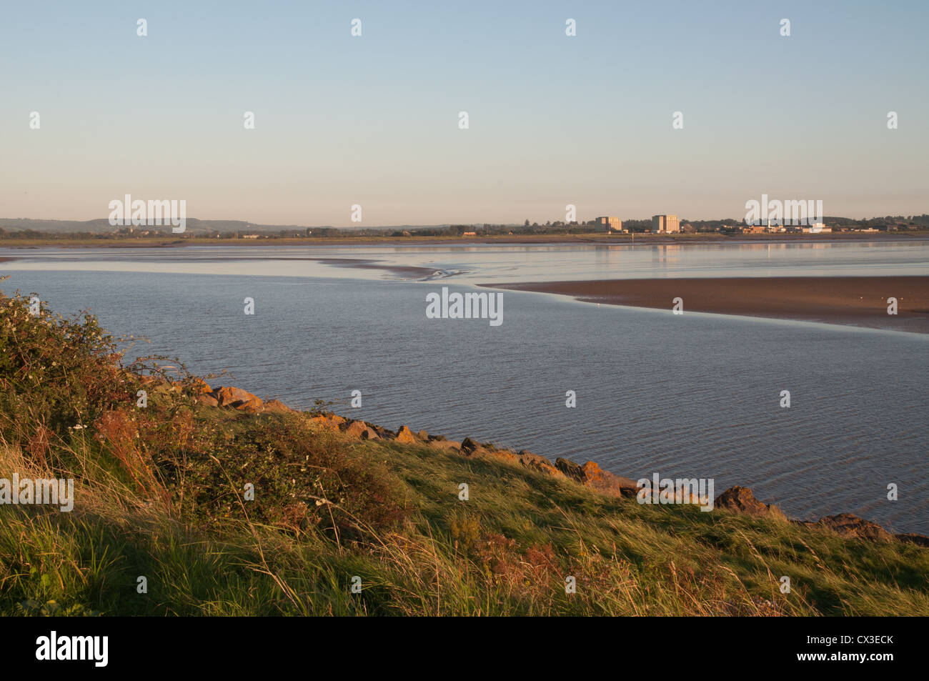 Fiume Severn a bassa marea in condizioni di scarsa luce solare con banca erbosa power station in background Foto Stock