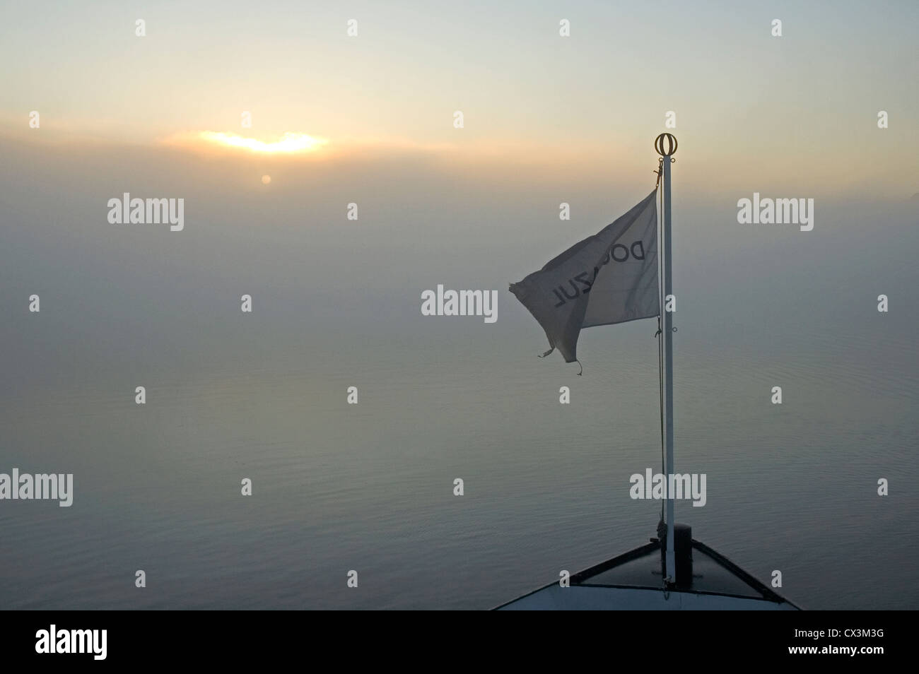 Il Portogallo, sul fiume Douro, sunrise attraverso la nebbia con bandiera della nave Foto Stock
