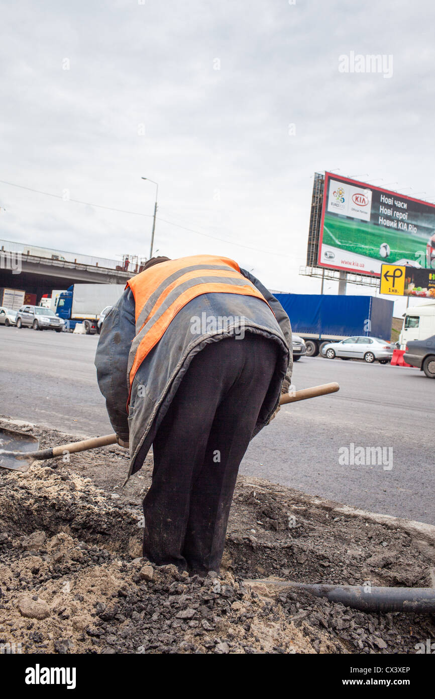 I lavoratori di cui un cavo di fronte a una strada a Kiev, in Ucraina, in Europa orientale. Foto Stock