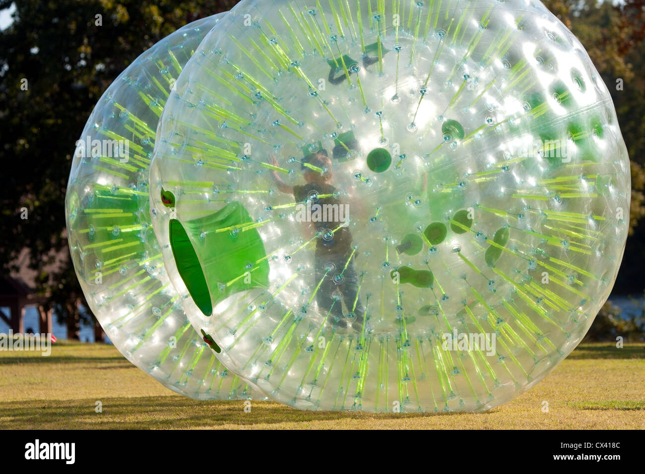 Un bambino che gioca all'interno di un zorb spinge dall'interno, ad un festival di caduta. Foto Stock