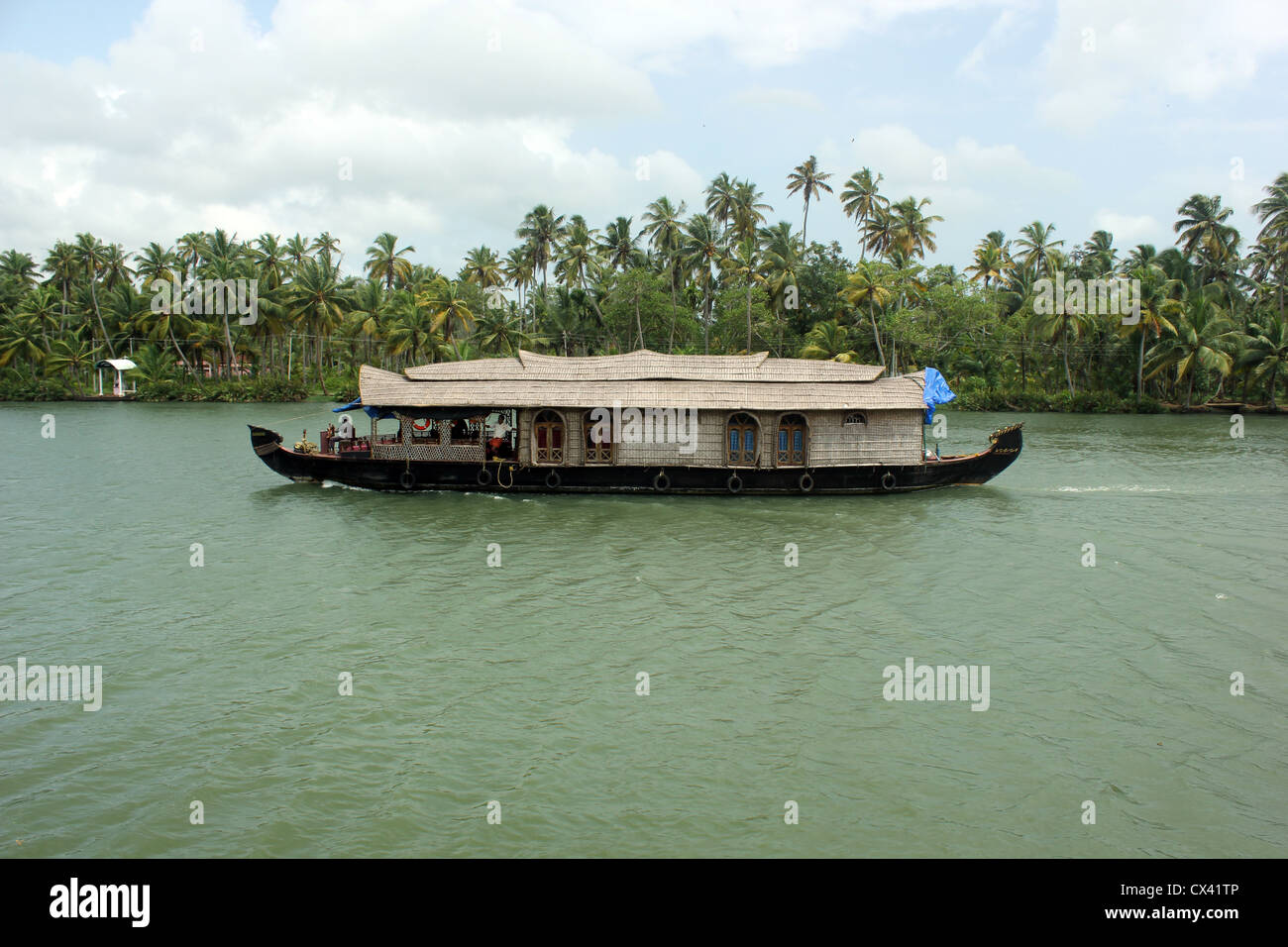 Una tradizionale casa galleggiante vela attraverso il lago Ashtamudi Foto Stock