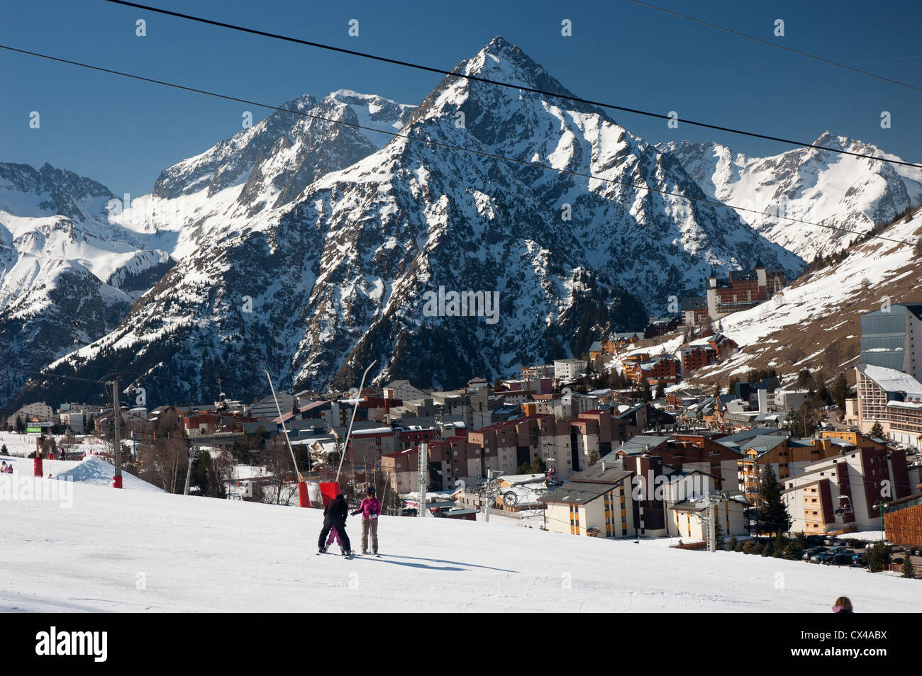 Pendenza sci con gli sciatori circondata da montagne di Les 2 Alpes, sulle Alpi francesi Foto Stock