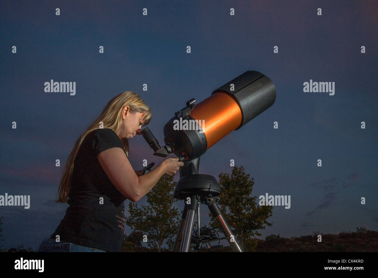 Una giovane donna astronomo dilettante utilizza un 2,000mm catadioptic telescopio per guardare le stelle su una serata in Orange County, CA. Foto Stock