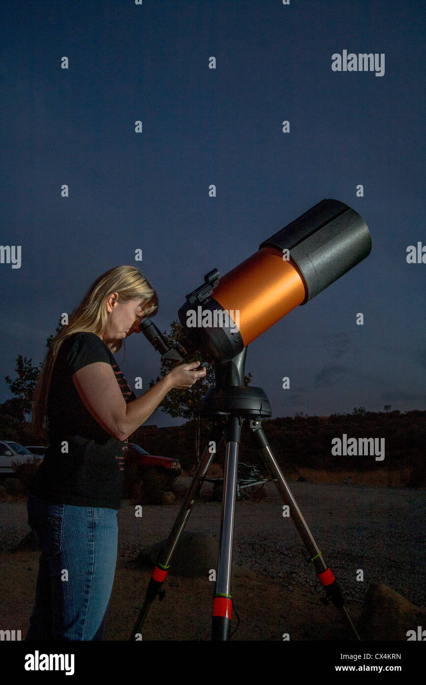 Una giovane donna astronomo dilettante utilizza un 2,000mm catadioptic telescopio per guardare le stelle su una serata in Orange County, CA. Foto Stock
