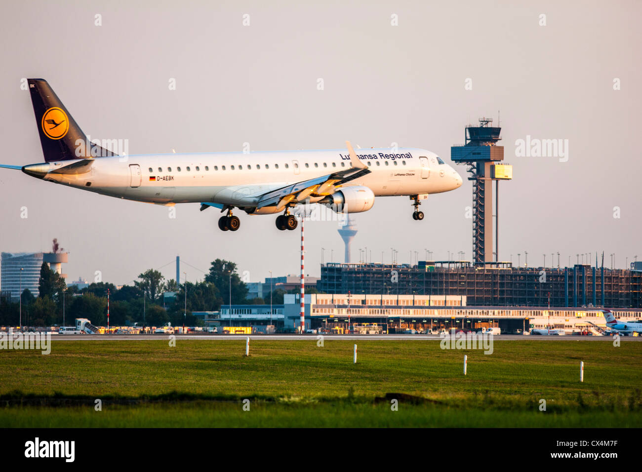 Aereo passeggeri avvicinando l'Aeroporto Internazionale di Düsseldorf. Toccare in basso nella parte anteriore del traffico aereo della torre di controllo. Germania Foto Stock