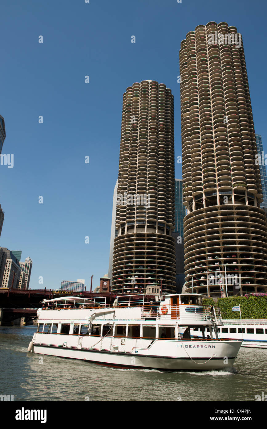 Marina City, noto anche come il tutolo di mais edifici sul Fiume di Chicago con un battello da crociera in primo piano in una giornata di sole. Foto Stock