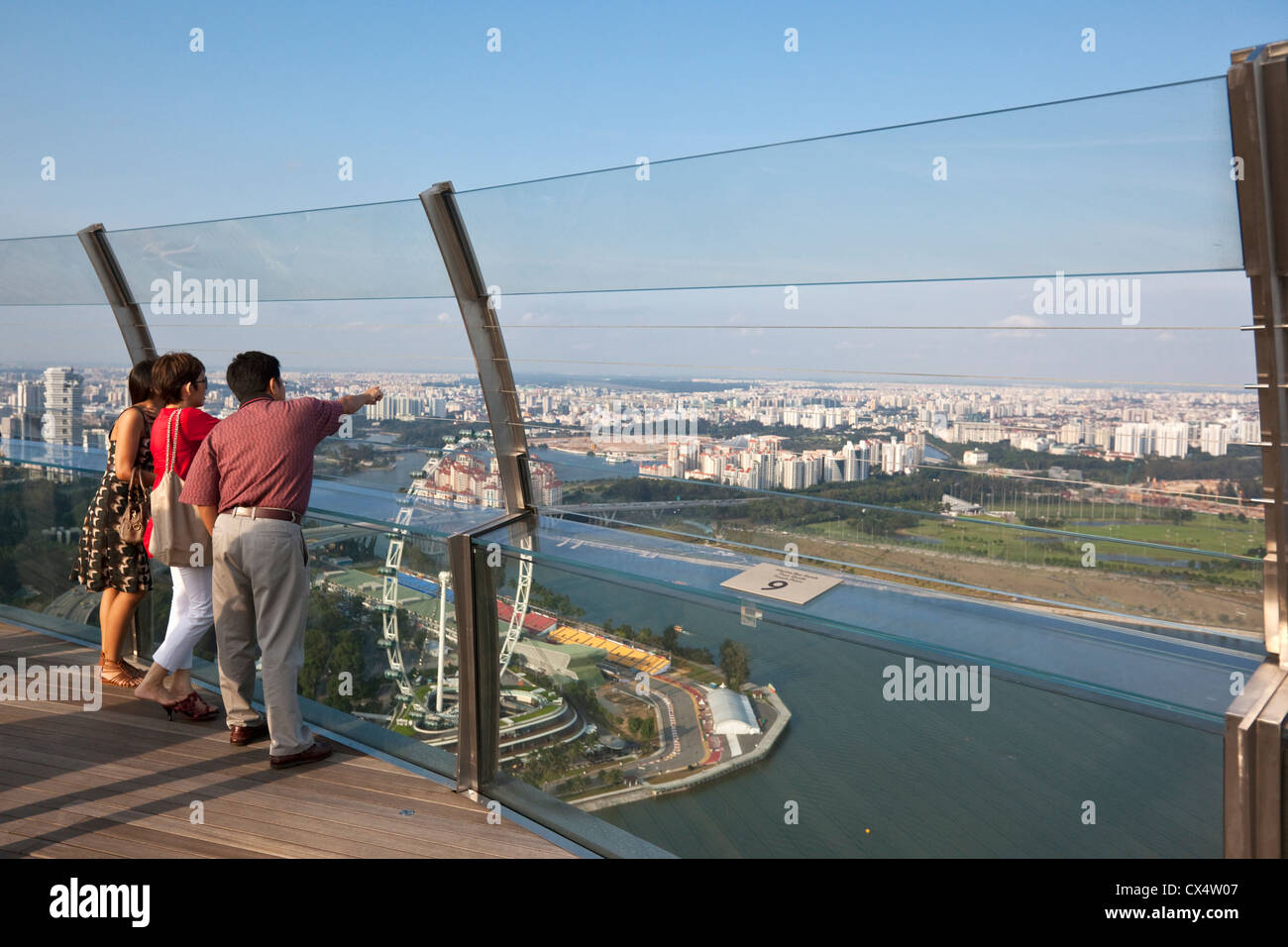 Gli ospiti si affacciano su Singapore dal ponte di osservazione della Marina Bay Sands SkyPark. Il Marina Bay, Singapore Foto Stock