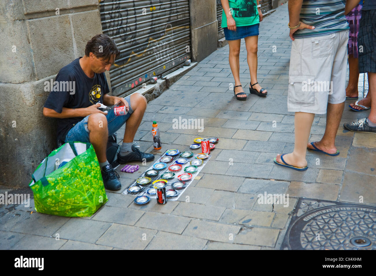 Barcellona venditore ambulante rendendo posacenere fuori di lattine per bevande in Barcellona Catalonia Spagna ES Foto Stock