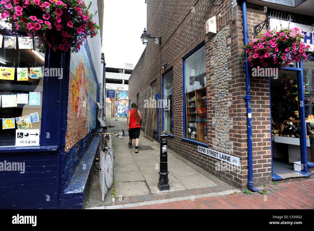 Un uomo cammina verso il basso Bond Street Laine in Brighton, gli storici locali dire laine si applica solo alle zone che una volta erano i seminativi Foto Stock
