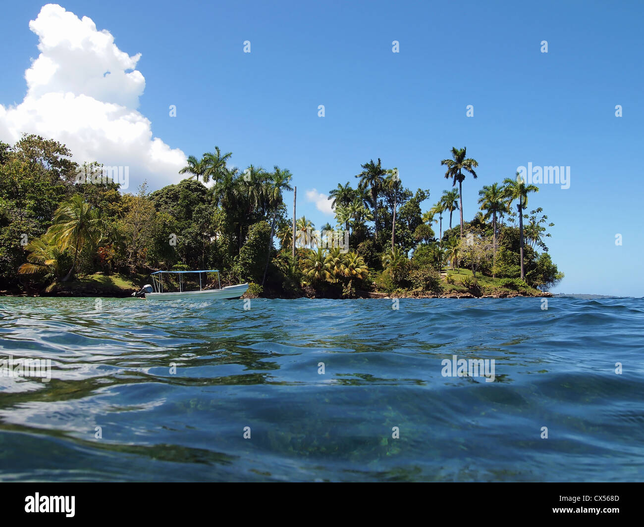 Barca nei pressi di un'isola tropicale con vegetazione bellissima Foto Stock
