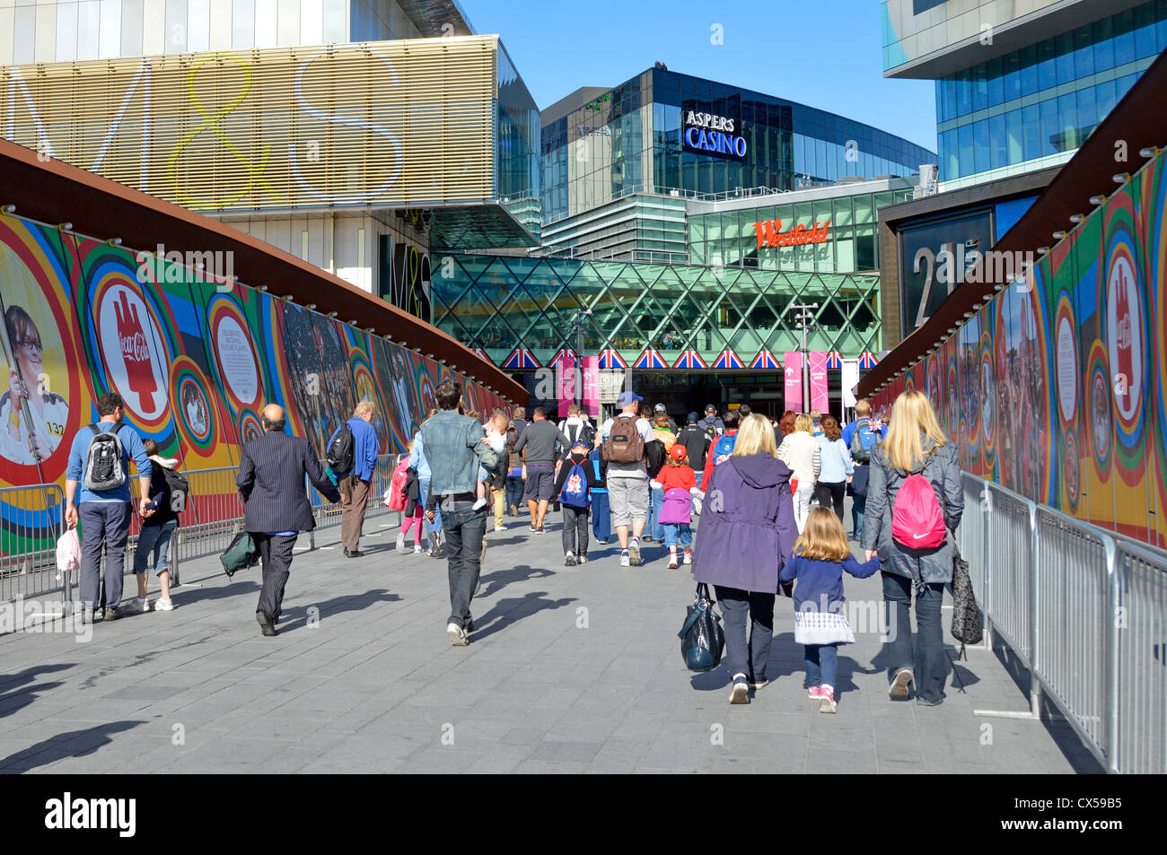 Gli spettatori e gli acquirenti su passerella che conduce al Westfield Shopping Malls & London 2012 Olympic Ingresso parco Foto Stock