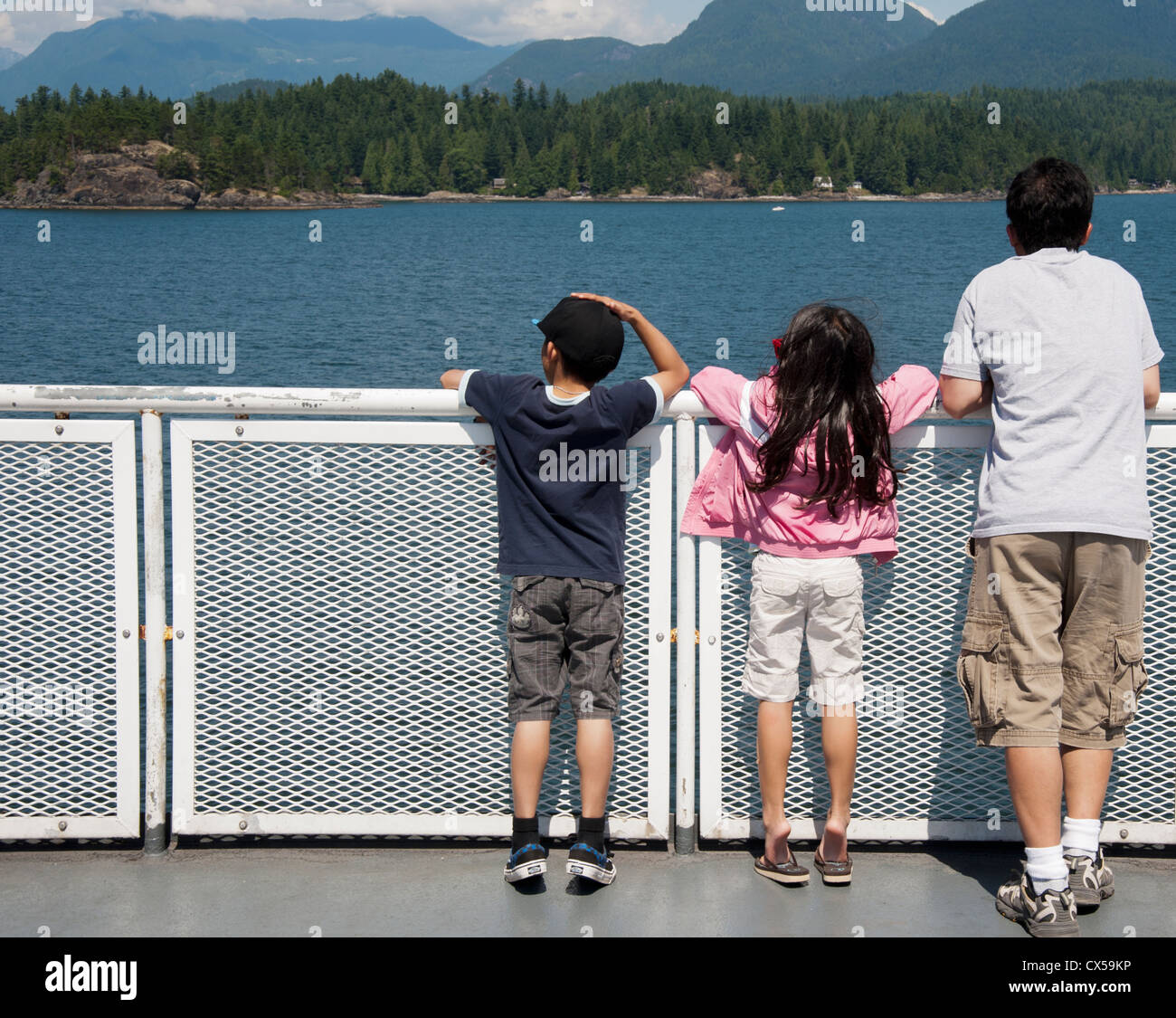 I turisti appoggiata contro la ringhiera su un British Columbia ferry scenic viaggio dalla baia a ferro di cavallo per la Sunshine Coast, Canada Foto Stock
