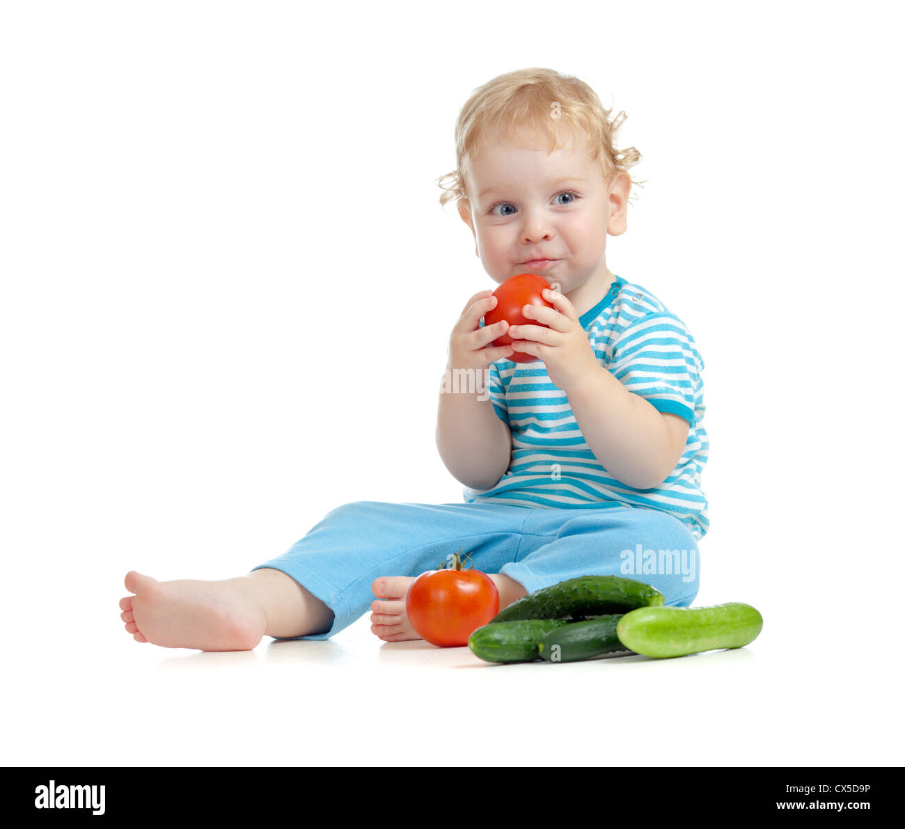 Bambino contento di mangiare i pomodori. Cibo sano concetto di mangiare. Foto Stock