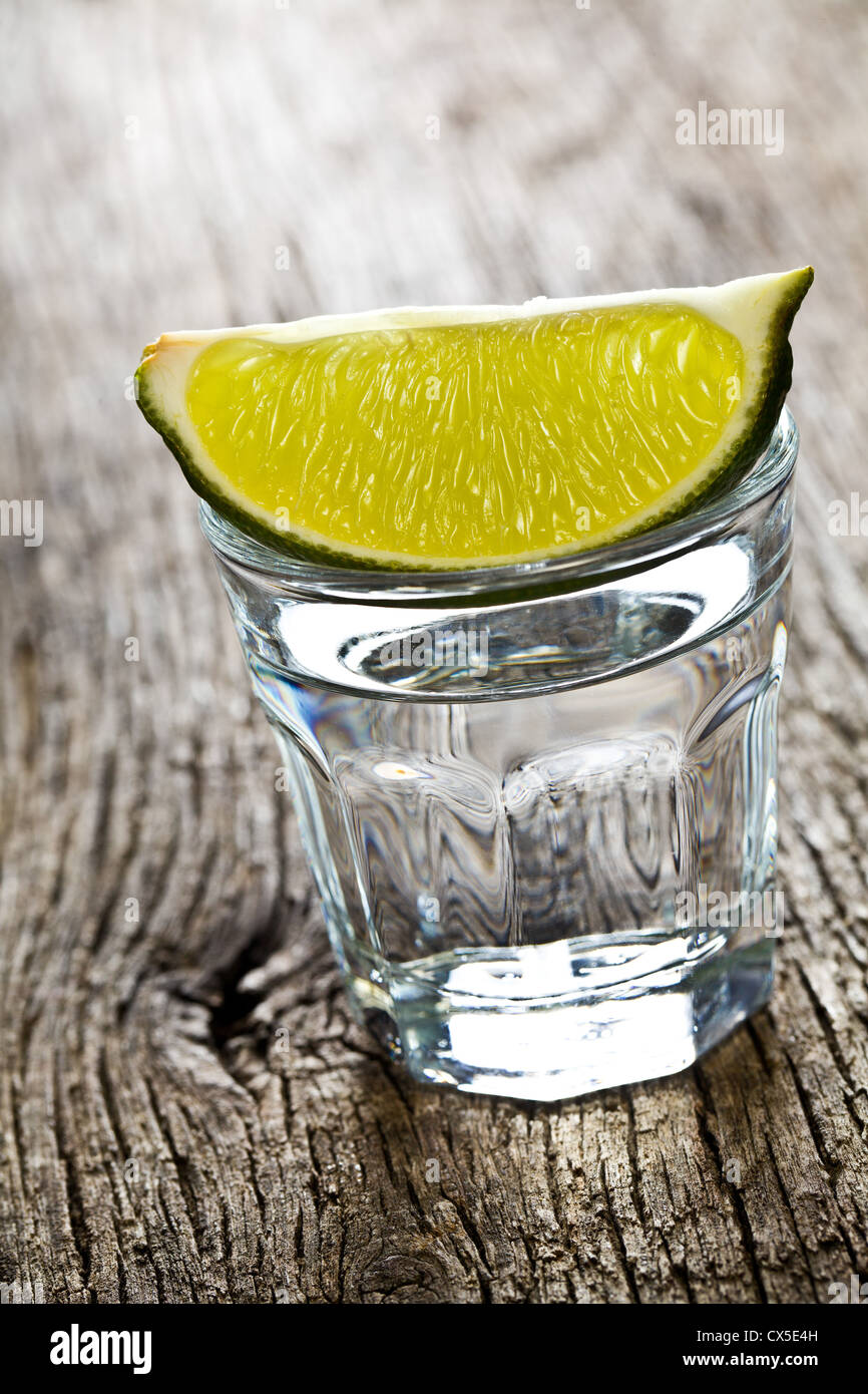 In vetro trasparente di alcool sul vecchio tavolo in legno Foto Stock