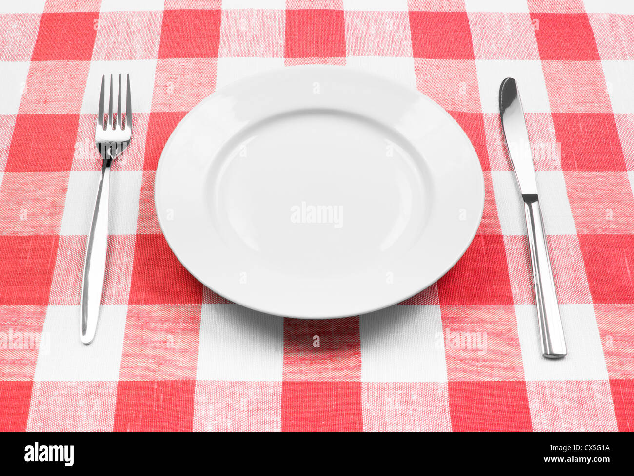 Coltello, piastra bianca e la forcella sul rosso tovaglia controllati Foto Stock