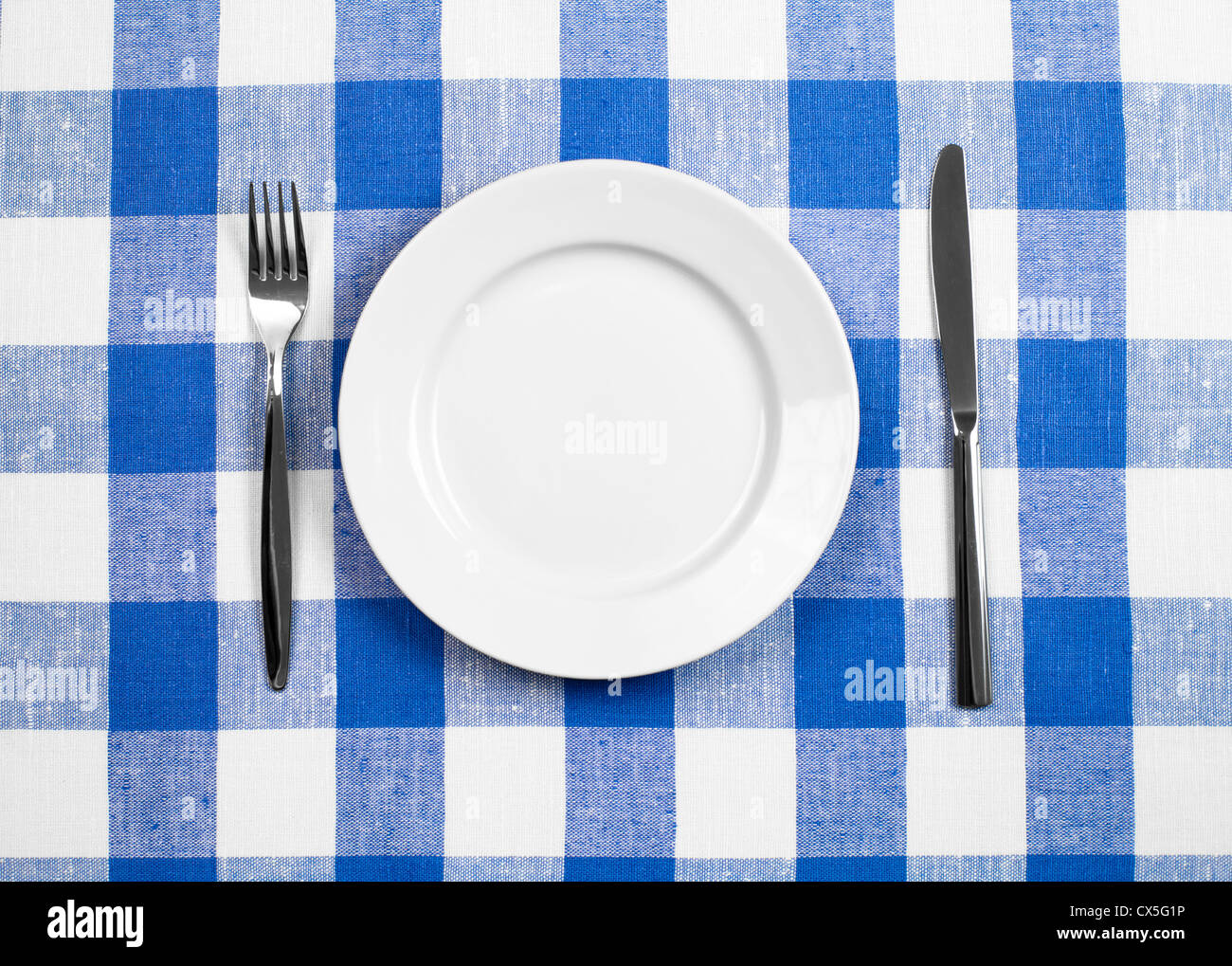 Coltello, piastra bianca e la forcella sul blu tovaglia controllati Foto Stock