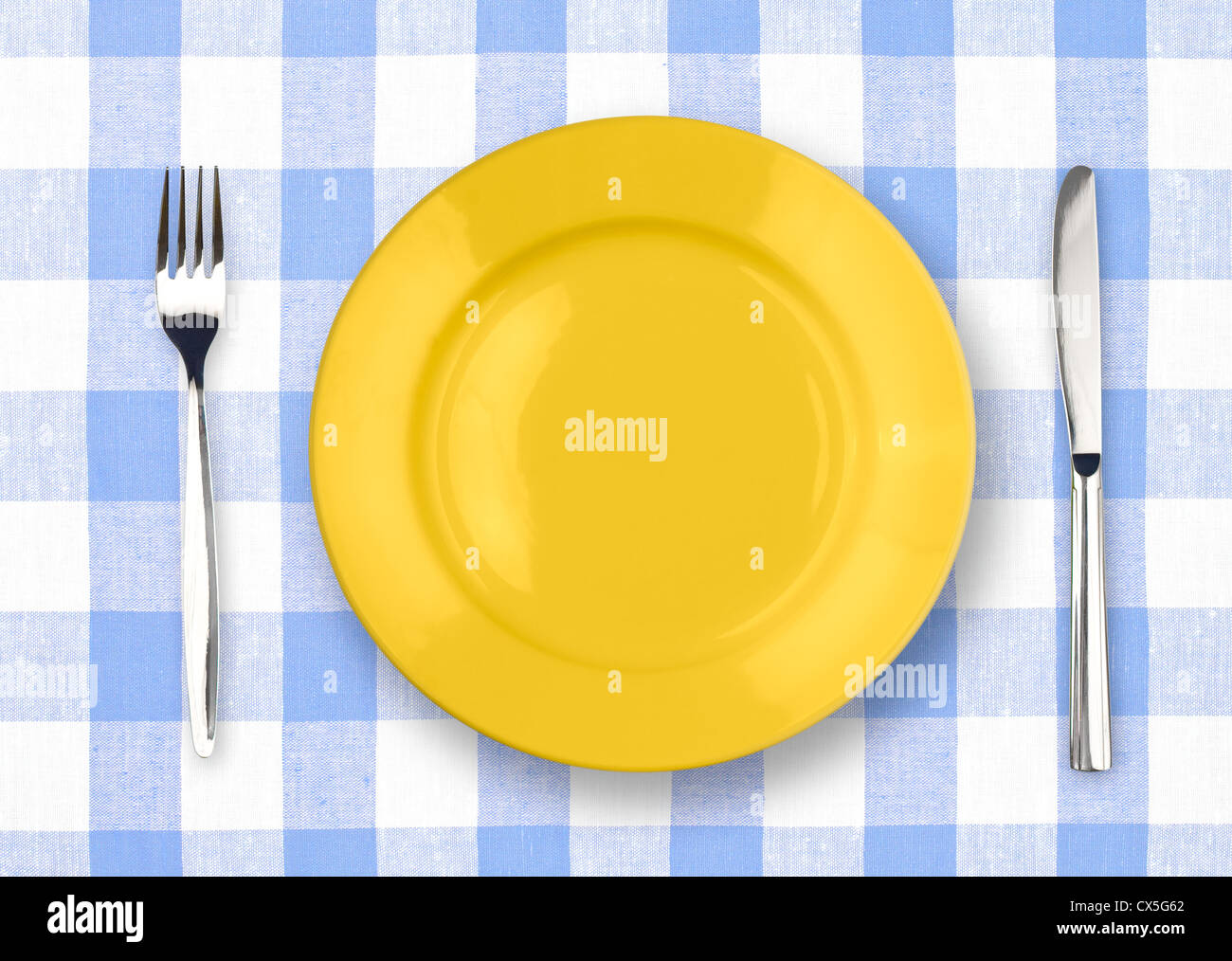 Coltello, piastra di colore giallo e la forcella sul giallo tovaglia controllati Foto Stock