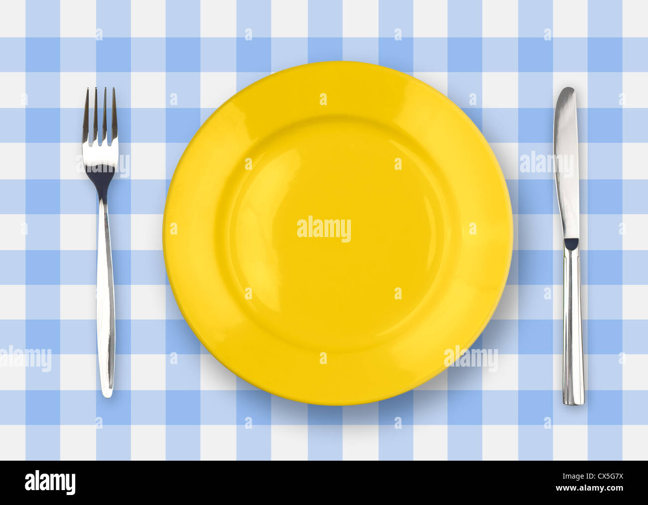 Coltello, piastra di colore giallo e la forcella sul giallo tovaglia controllati Foto Stock