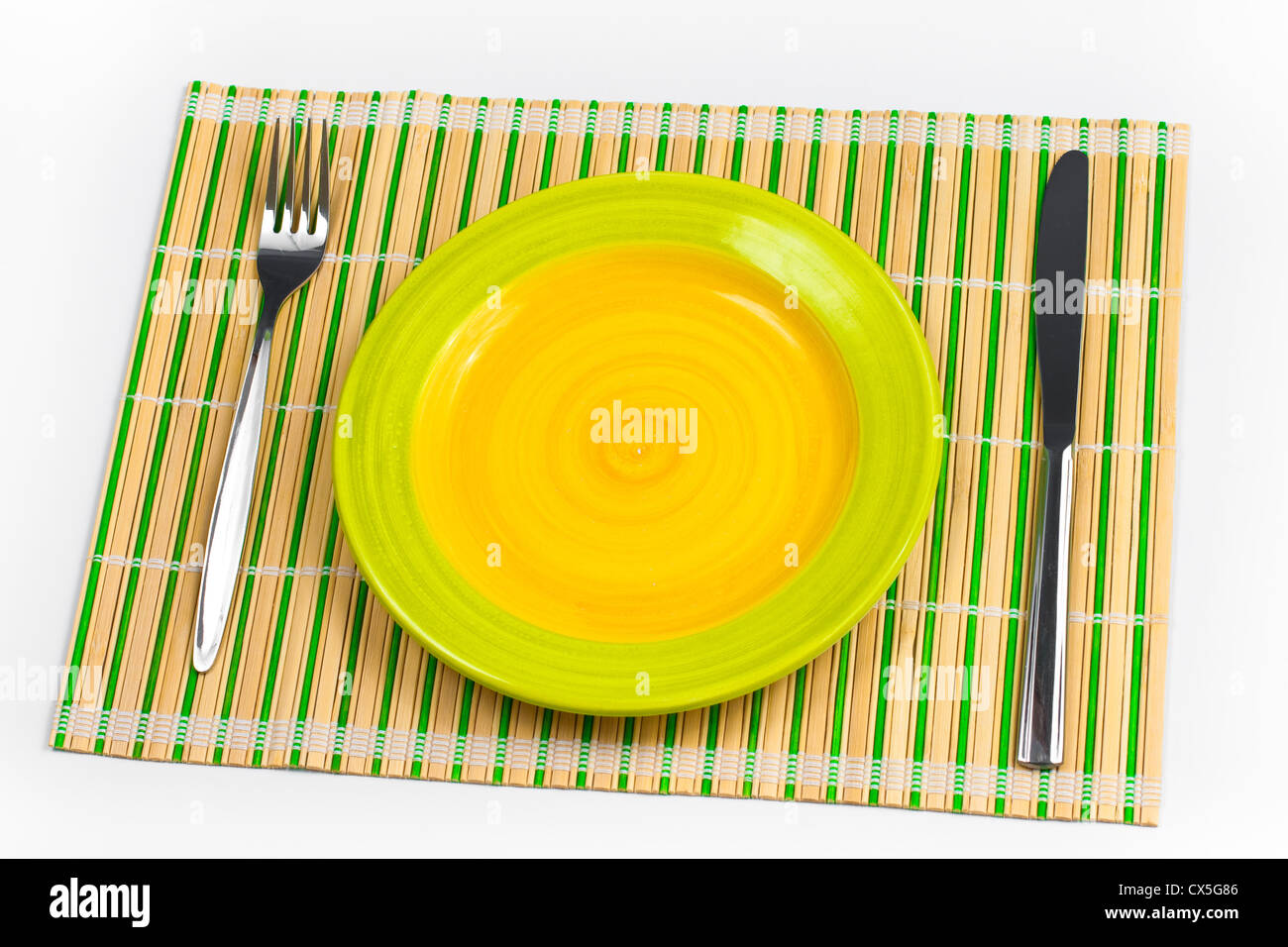 Placemat di bambù con piastra forchetta e coltello isolato su bianco Foto Stock